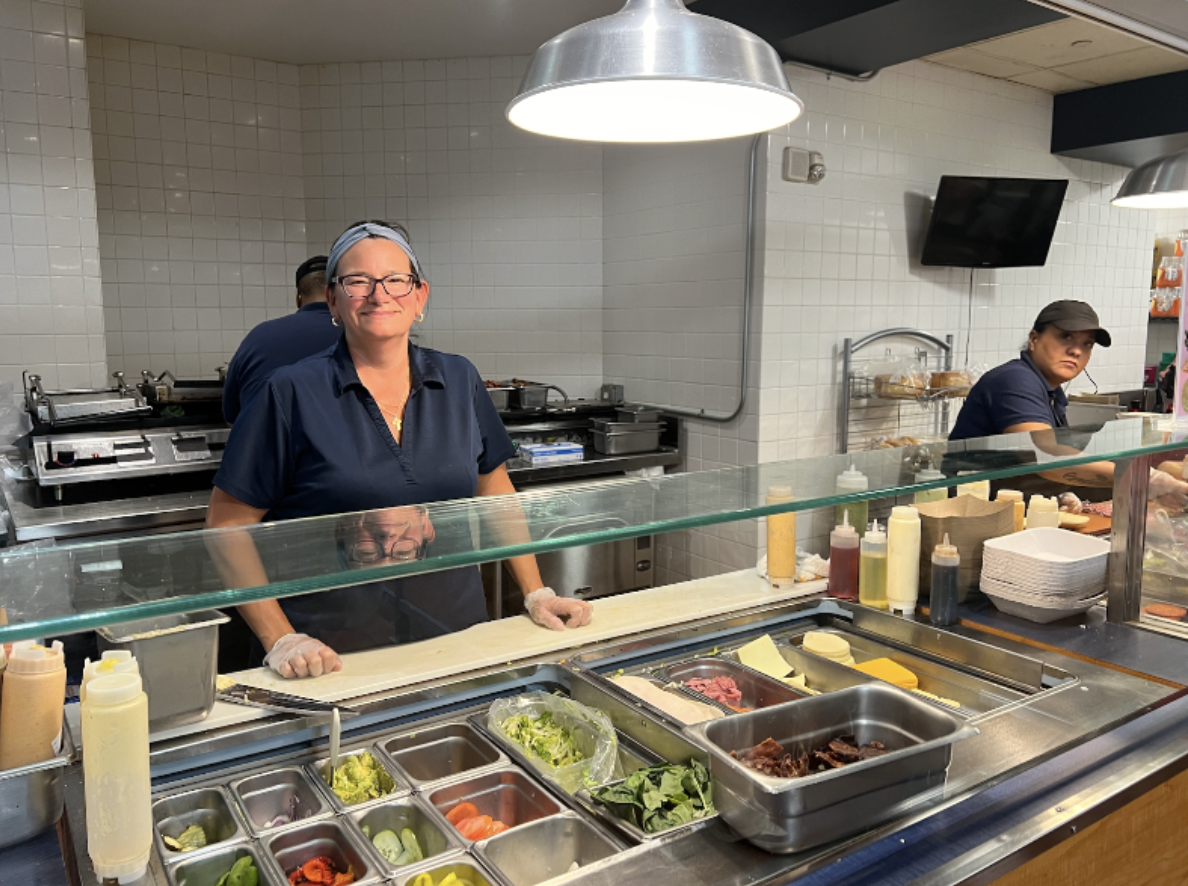 Deli worker Amber Egereari keeps the bustling sandwich line moving as she quickly crafts students' orders.